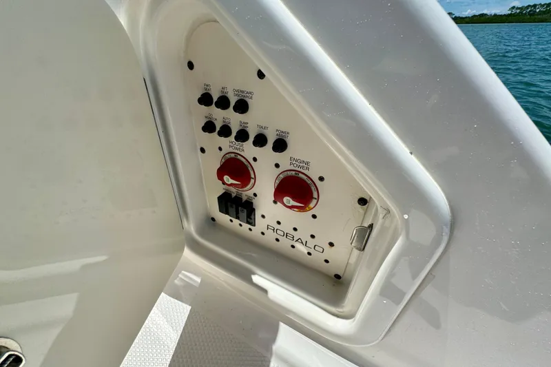 Slide: The Image of Control panel of 2019 Robalo R317 Dual Console boat, featuring switches and power controls. - 52