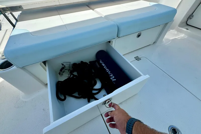 Slide: The Image of Open storage drawer on 2019 Robalo R317 Dual Console boat, containing ropes and accessories. - 53