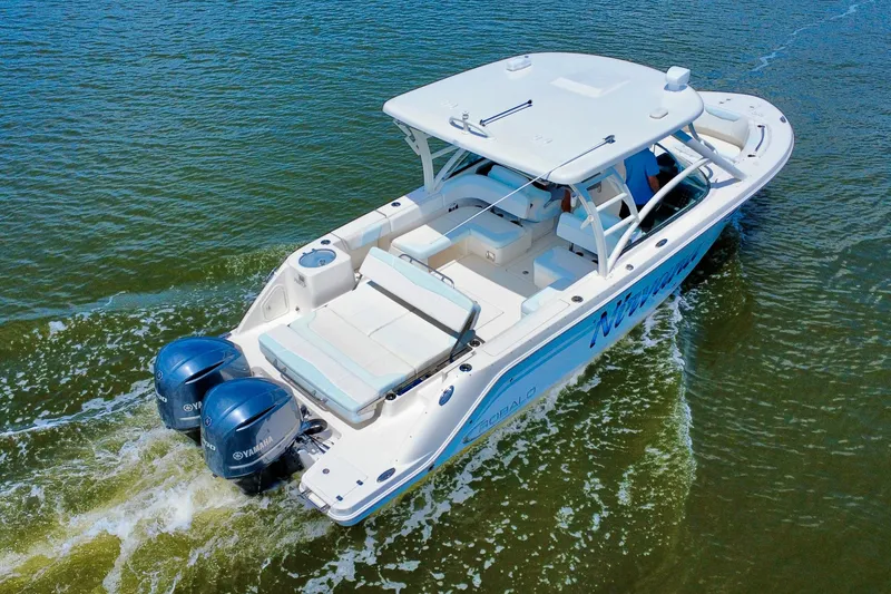Slide: The Image of 2019 Robalo R317 Dual Console boat cruising on water with twin Yamaha engines. - 7