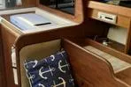 Slide: The Image of Interior of a 1977 Columbia 31 sailboat with wooden cabinetry and nautical-themed cushion. - 8