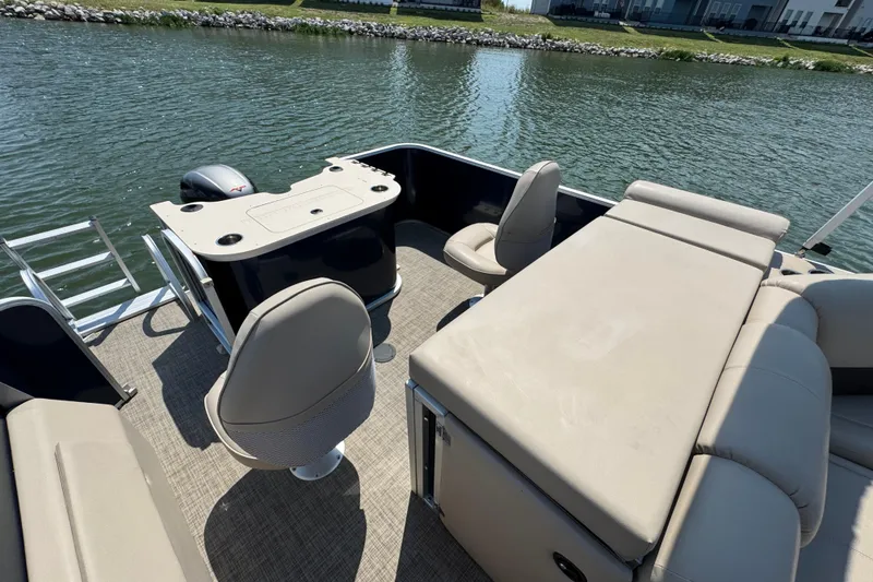 Slide: The Image of 2019 G3 X22FC pontoon boat interior with seating and helm, on a calm lake. - 19