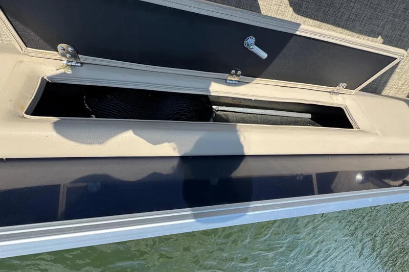 Slide: The Image of Open storage compartment on a 2019 G3 X22FC boat, with water in the background. - 23