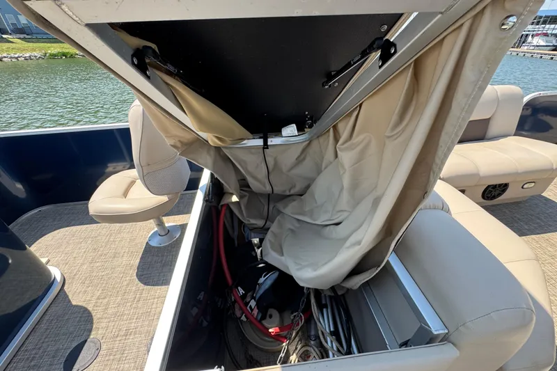 Slide: The Image of Open storage compartment on a 2019 G3 X22FC boat, revealing interior equipment and seating. - 26