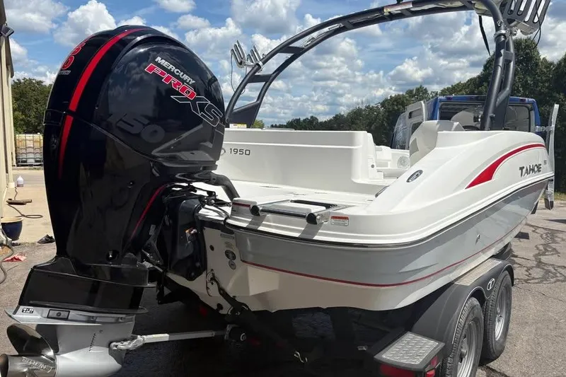Slide: The Image of 2022 Tahoe 1950 boat with Mercury Pro XS engine, parked outdoors under a cloudy sky. - 2