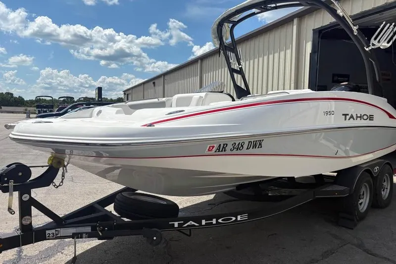 Slide: The Image of 2022 Tahoe 1950 boat on trailer, parked outdoors under a blue sky. - 5