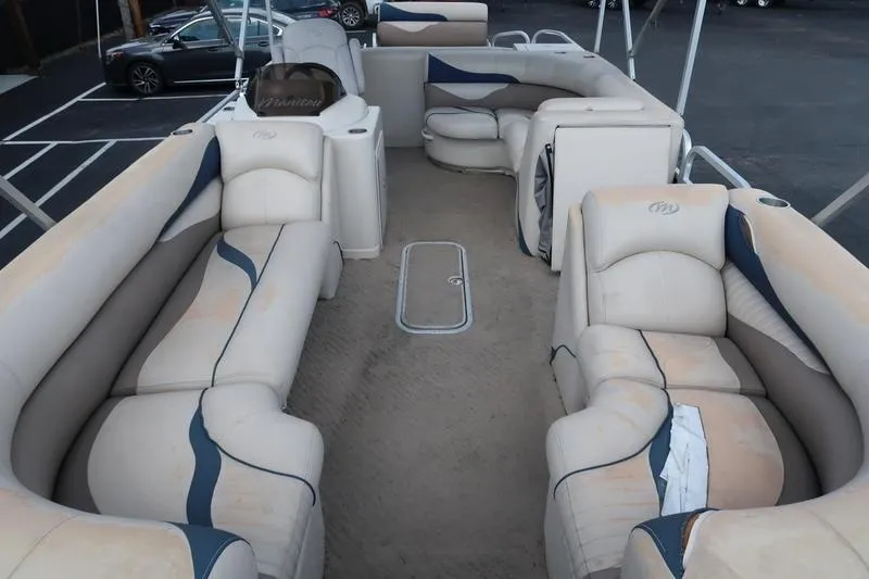 Slide: The Image of 2012 Manitou 24 Oasis Tri-Toon boat interior with beige seating and spacious layout. - 12