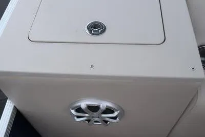 Slide: The Image of 2012 Manitou 24 Oasis Tri-Toon boat storage compartment with speaker detail. - 16