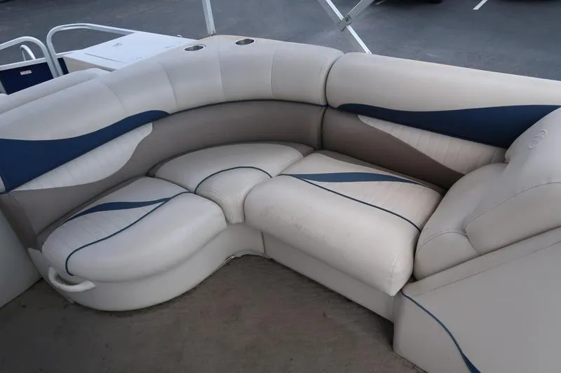 Slide: The Image of 2012 Manitou 24 Oasis Tri-Toon boat seating with white and blue upholstery. - 6