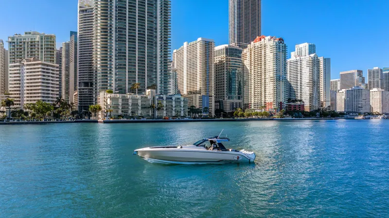 Slide: The Image of 2022 Cigarette 42 Auroris boat cruising near city skyscrapers on a sunny day. - 7