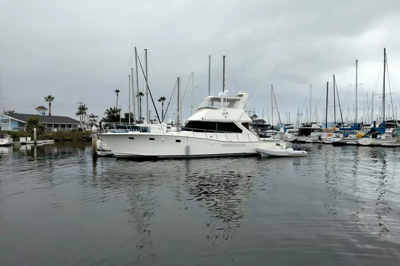 The Image of 1985 50' Pacifica Long Range Sportfisherman docked in a marina with sailboats. - 1