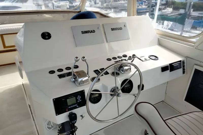 Slide: The Image of 1985 50' Pacifica Long Range Sportfisherman helm with Simrad navigation equipment and steering wheel. - 10