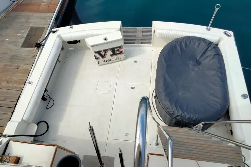 Slide: The Image of 1985 50' Pacifica Long Range Sportfisherman deck with covered equipment and dock view. - 4