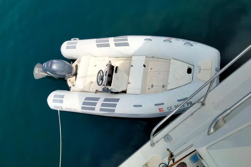 Slide: The Image of White inflatable boat with outboard motor, docked beside a 1985 50' Pacifica Long Range Sportfisherman. - 6