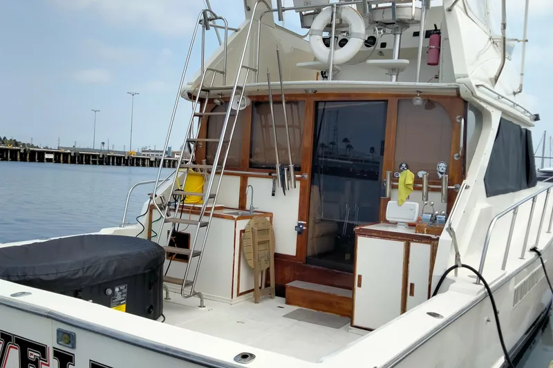 Slide: The Image of 1985 50' Pacifica Long Range Sportfisherman docked, featuring fishing equipment and cabin access. - 7