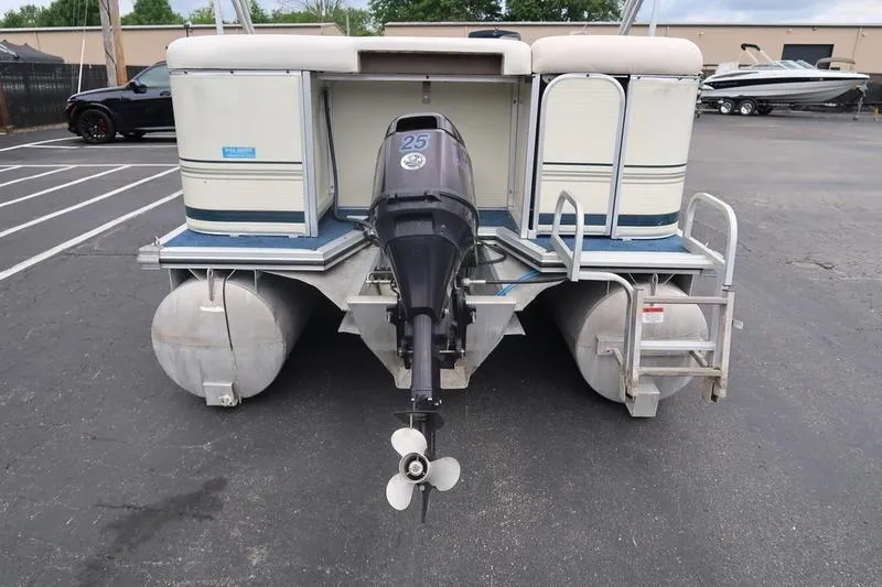 Slide: The Image of 2002 Lowe Trinidad 200 pontoon boat with outboard motor in a parking lot. - 11