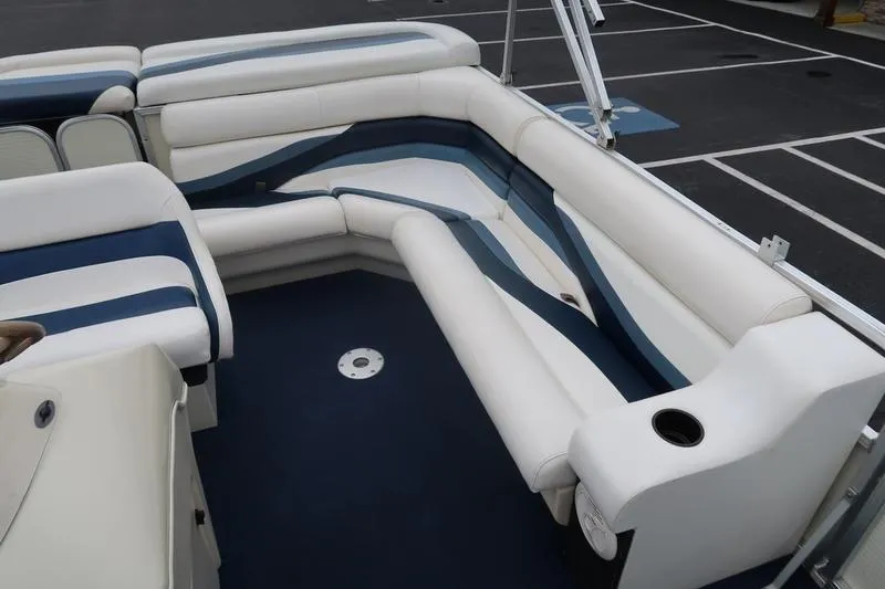 Slide: The Image of Interior of a 2002 Lowe Trinidad 200 boat with white and blue seating. - 13