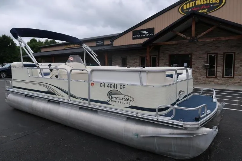 Slide: The Image of 2002 Lowe Trinidad 200 pontoon boat parked outside dealership. - 2