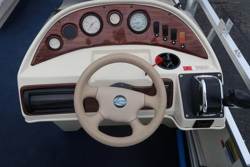 Slide: The Image of Steering console of a 2002 Lowe Trinadad 200 boat with gauges and controls. - 23