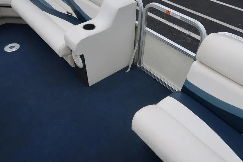 Slide: The Image of Interior of a 2002 Lowe Trinadad 200 boat with blue and white seating. - 4