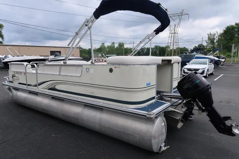 Slide: The Image of 2002 Lowe Trinidad 200 pontoon boat with outboard motor in a parking lot. - 9