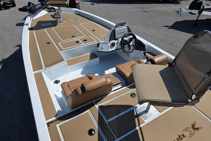 Slide: The Image of 2026 Xpress H20C Crappie boat interior with tan seating and Garmin electronics. - 13