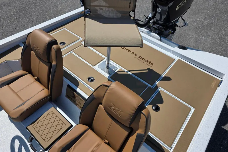 Slide: The Image of 2026 Xpress H20C Crappie boat interior with tan seating and storage compartments. - 21