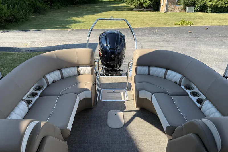 Slide: The Image of 2025 Bennington 23 LXSFB pontoon boat interior with plush seating and outboard motor. - 12