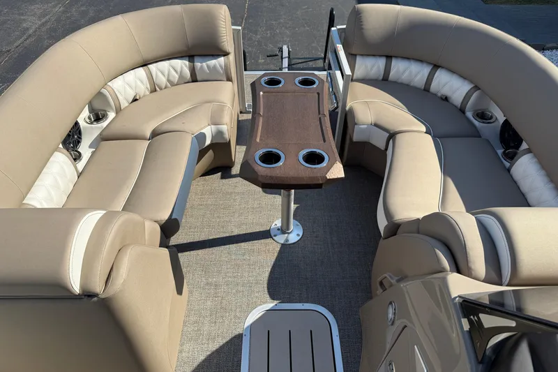 Slide: The Image of 2025 Bennington 23 LXSFB pontoon boat interior with beige seating and central table. - 17