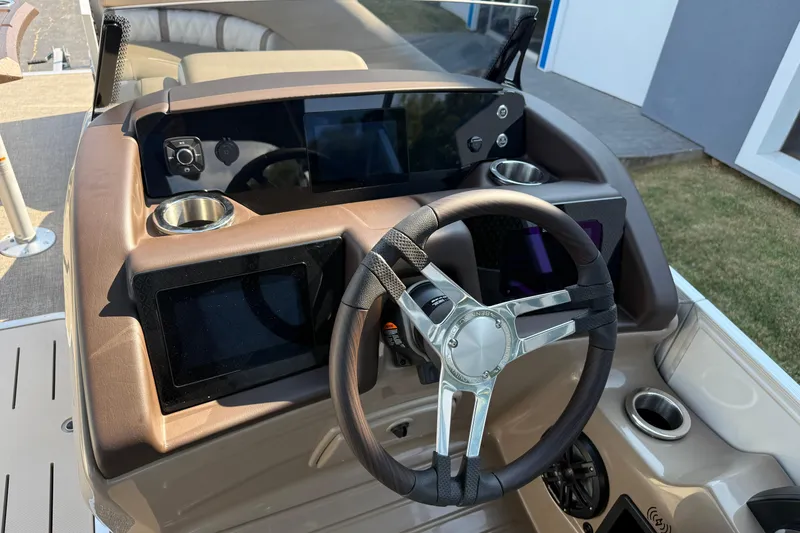 Slide: The Image of 2025 Bennington 23 LXSFB boat dashboard with steering wheel and digital displays. - 18