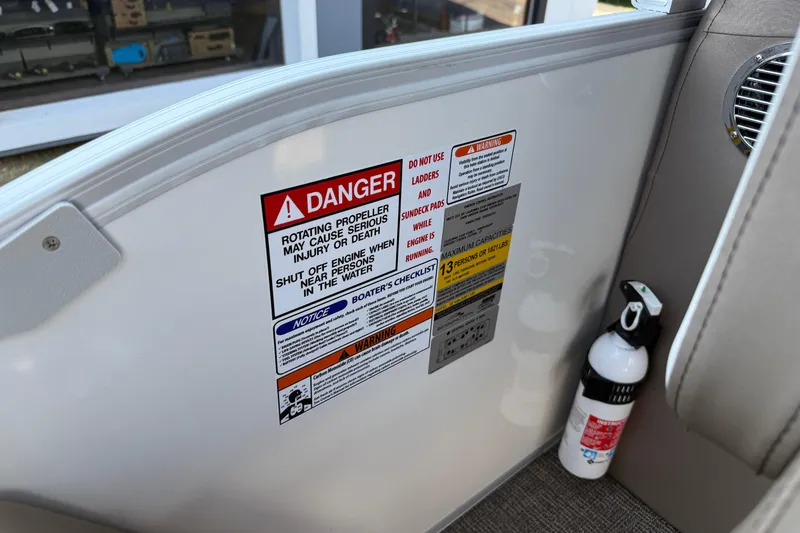 Slide: The Image of Safety warnings and fire extinguisher on 2025 Bennington 23 LXSFB boat interior. - 21