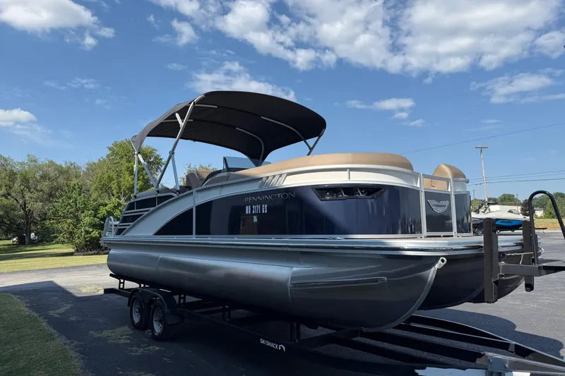 Slide: The Image of 2025 Bennington 23 LXSFB pontoon boat on trailer under blue sky. - 4