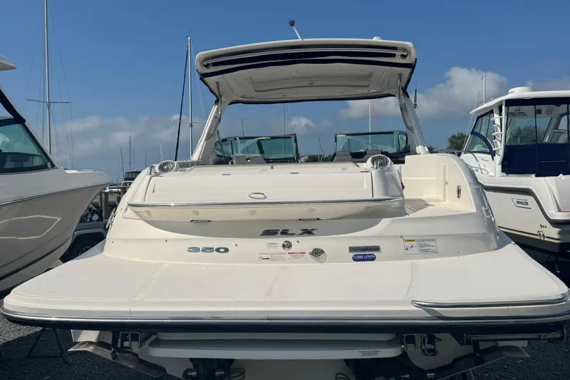 Slide: The Image of 2016 Sea Ray 350 SLX boat docked, rear view, showcasing spacious deck and sleek design. - 17