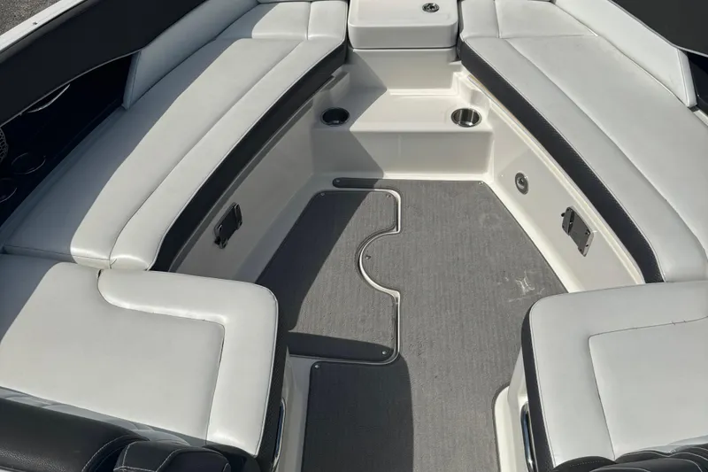 Slide: The Image of 2016 Sea Ray 350 SLX boat interior with white cushioned seating and gray flooring. - 6