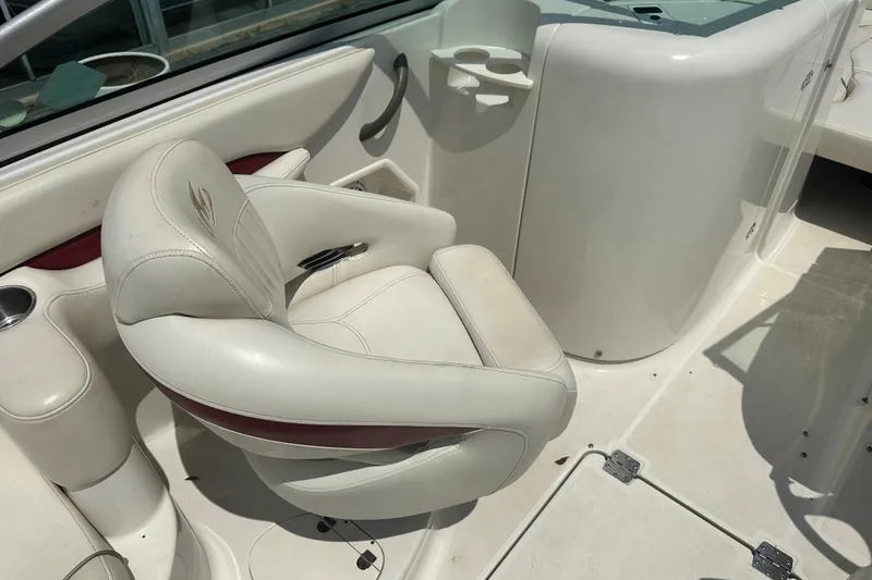 Slide: The Image of 2007 Monterey 263 Explorer Deck Boat interior with white captain's chair and cup holders. - 11