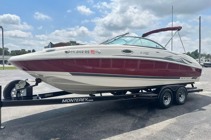 Slide: The Image of 2007 Monterey 263 Explorer Deck Boat on trailer, red and white design, parked outdoors. - 6