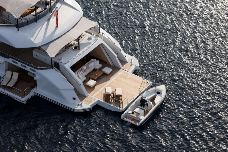 Slide: The Image of Luxurious Alia Yachts 60M, 2016 model, with elegant deck and tender on serene water. - 2