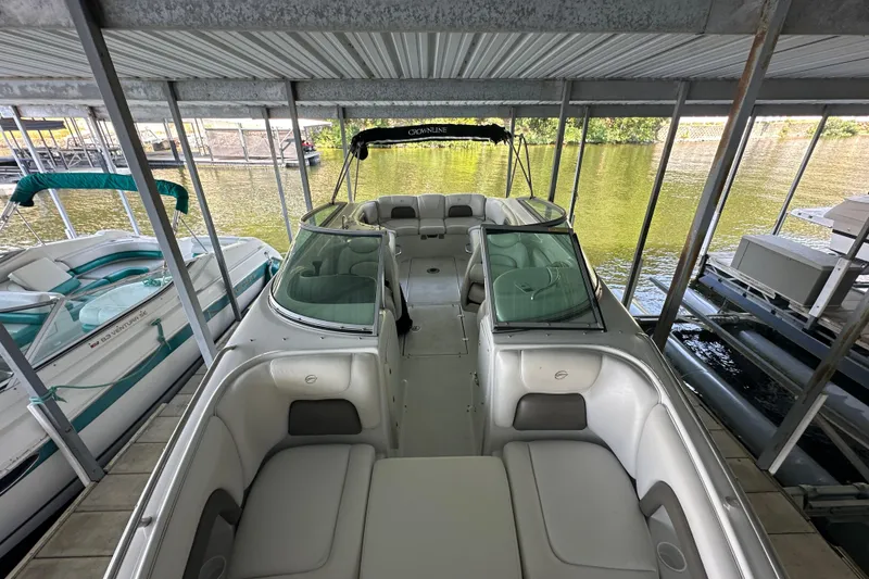 Slide: The Image of 2005 Crownline 270 BR boat docked in a covered marina, featuring spacious seating. - 11