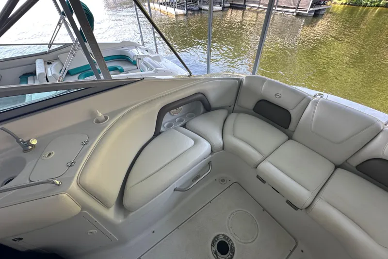 Slide: The Image of 2005 Crownline 270 BR boat interior with beige seating and lake view. - 15