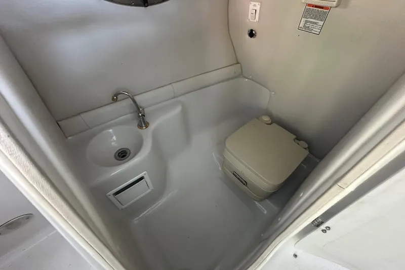 Slide: The Image of 2005 Crownline 270 BR boat bathroom with sink and portable toilet. - 29