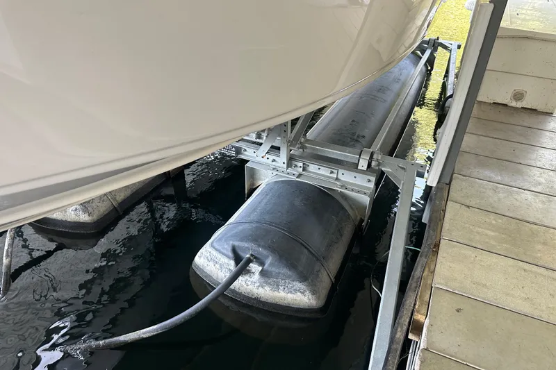 Slide: The Image of 2005 Crownline 270 BR boat on a lift, partially submerged in water. - 44