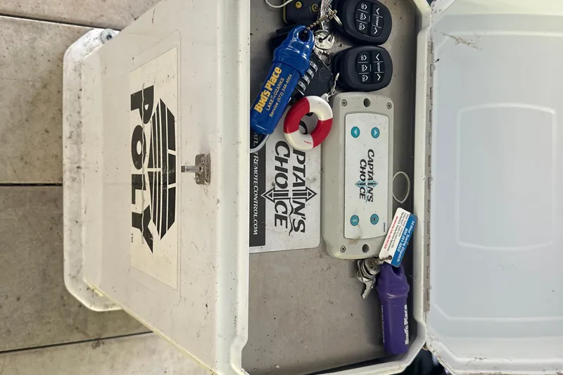 Slide: The Image of Open storage box with keys and remote controls for a 2005 Crownline 270 BR boat. - 45