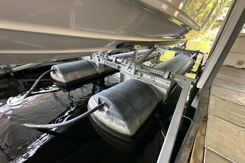 Slide: The Image of 2005 Crownline 270 BR boat on a dock lift system, partially submerged in water. - 47