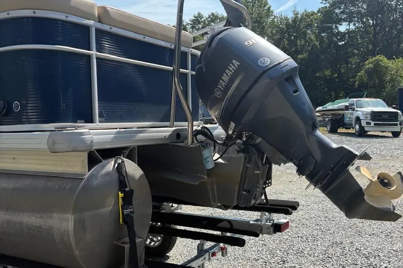 Slide: The Image of 2016 Godfrey SWEETWATER 2086 pontoon boat with Yamaha outboard motor, parked on gravel. - 2