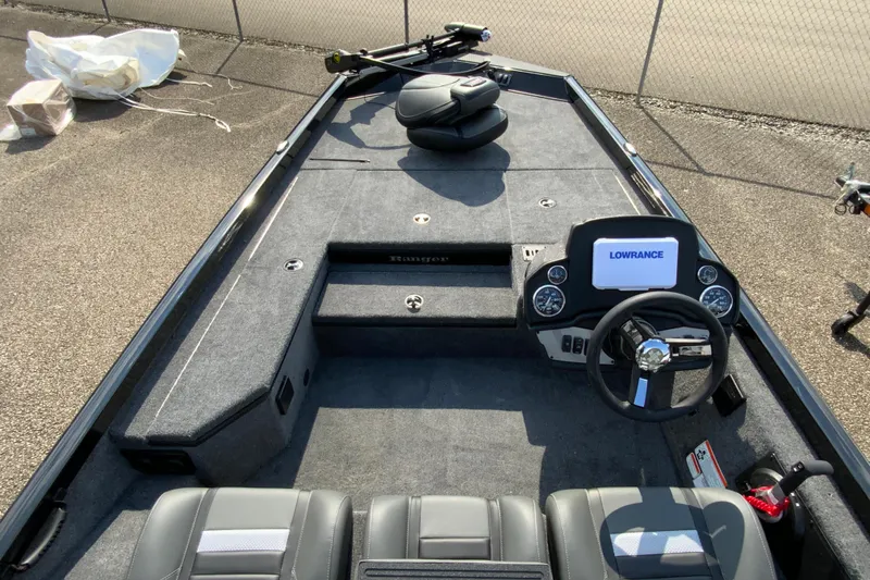 Slide: The Image of 2026 Ranger RT178 boat interior with Lowrance electronics and steering wheel, parked on pavement. - 6