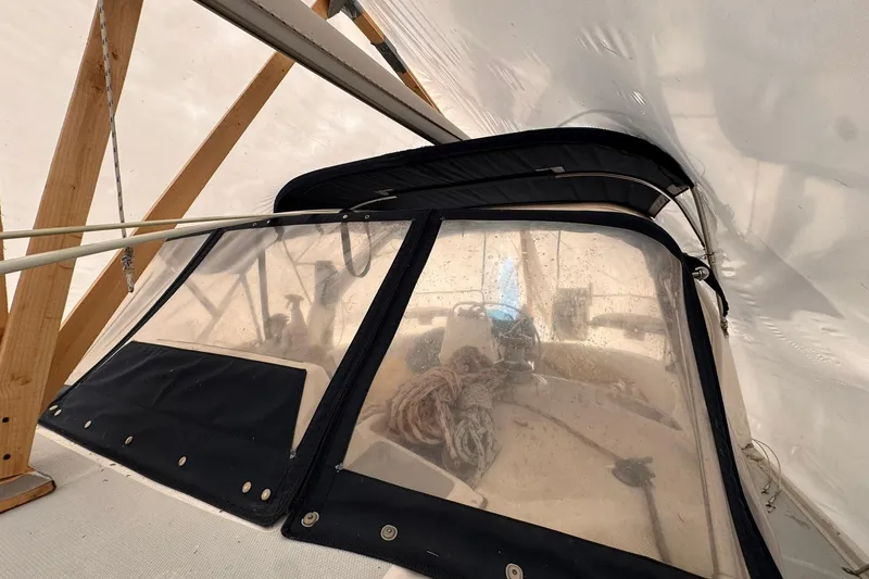 Slide: The Image of 1997 Hunter 340 sailboat cockpit under protective cover with ropes and wooden supports. - 10