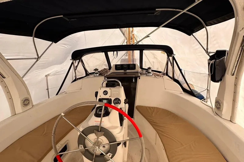Slide: The Image of Interior view of a 1997 Hunter 340 sailboat cockpit with steering wheel and navigation equipment. - 12