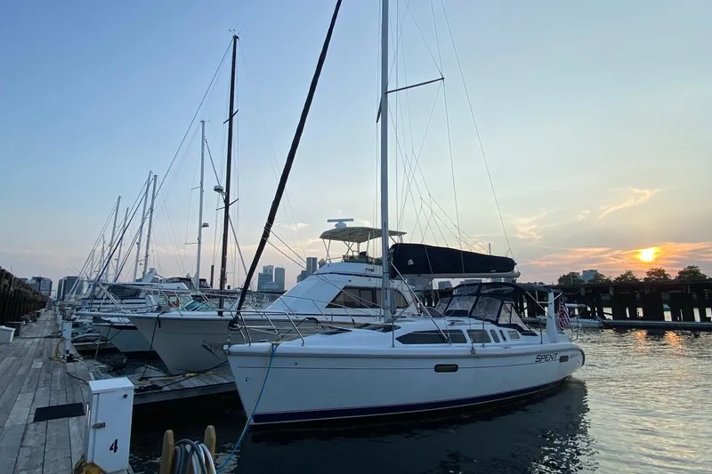 Slide: The Image of Sailboats docked at sunset, featuring a 1997 Hunter 340 model. - 2