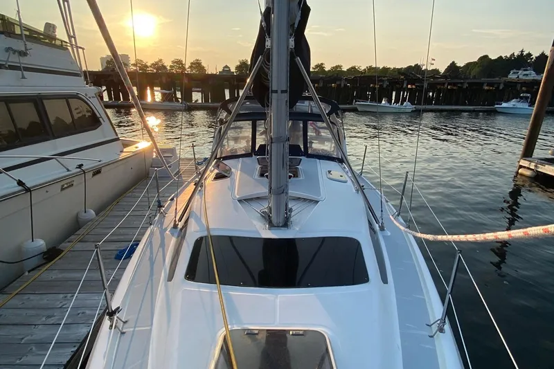 Slide: The Image of Sailboat Hunter 340, 1997 model, docked at sunset with scenic waterfront view. - 3