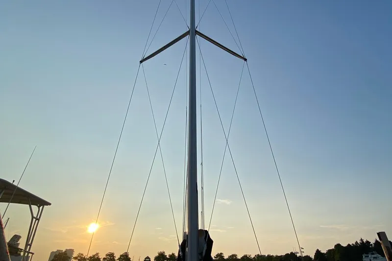 Slide: The Image of Mast of 1997 Hunter 340 sailboat against sunset sky, with silhouetted trees. - 4