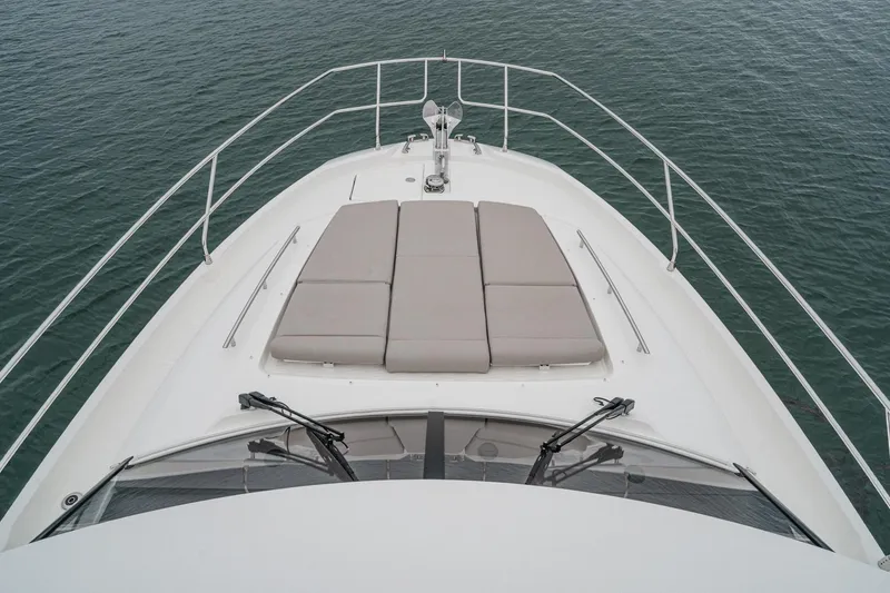 Slide: The Image of Prestige 420 Fly 2021 yacht bow with sunbathing cushions on calm water. - 15